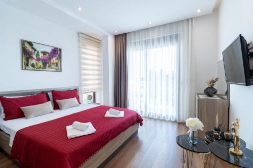 a bedroom with a large bed with a red blanket at Arte Luxury Pool Apartmets in Ulcinj