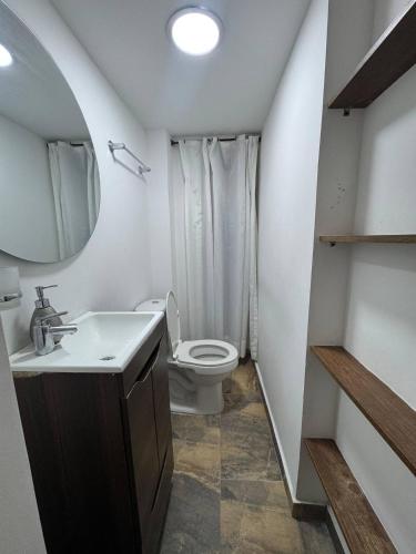 a bathroom with a toilet and a sink and a mirror at Casa Mama Hotel in Manizales