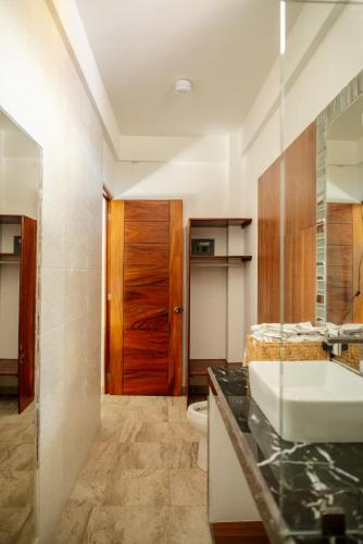 a bathroom with a sink and a toilet at Happy Beach - Playa Feliz in Ixtapa-Zihuatanejo International