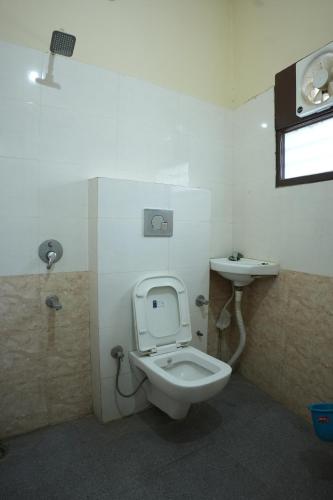 a bathroom with a toilet and a sink at Hotel Hari Sarovar in Kurukshetra