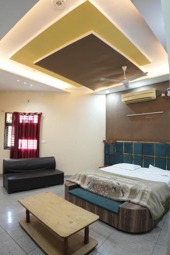 a bedroom with a bed and a coffee table at Hotel Hari Sarovar in Kurukshetra