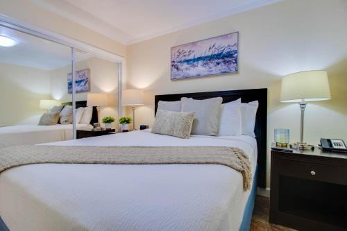 a bedroom with a large bed with white sheets and pillows at Waterfront, Sunset views from balcony, Heated pool in Tampa