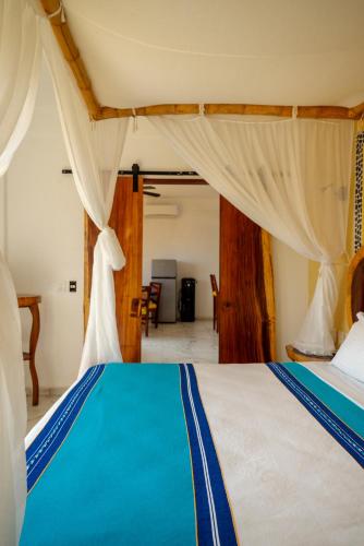a bedroom with a bed with blue and white sheets at Happy Beach - Playa Feliz in Ixtapa-Zihuatanejo International