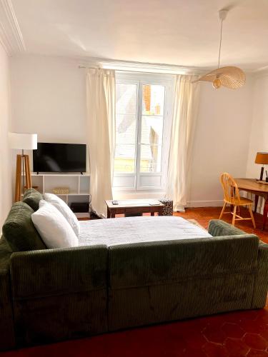 a bedroom with a couch and a large window at Charmant 2 pièces - centre historique - Vieux Mans in Le Mans