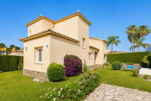 a house with a garden in front of it at Villa Oliva Nova - Private Pool in Casas Devesa