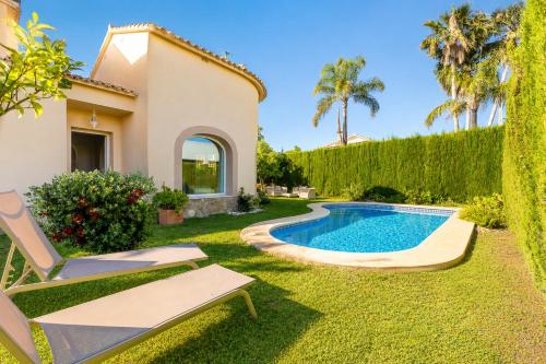 a villa with a swimming pool in a yard at Villa Oliva Nova - Private Pool in Casas Devesa