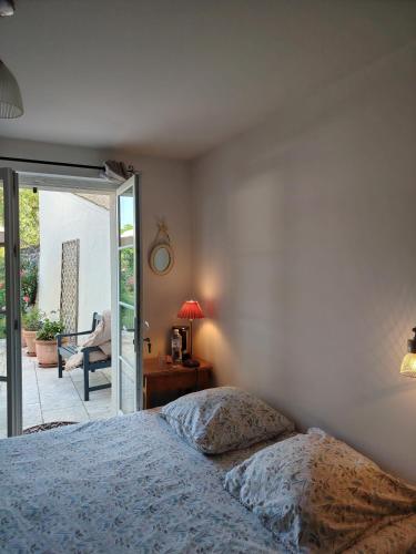a bedroom with a bed and a sliding glass door at Chambre d'hôte Montlivault / Chambord in Montlivault