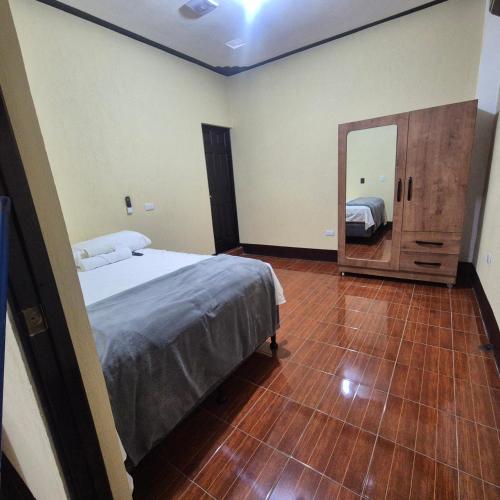 a bedroom with a bed and a large mirror at Estadía Climatizada en Escuintla in Escuintla