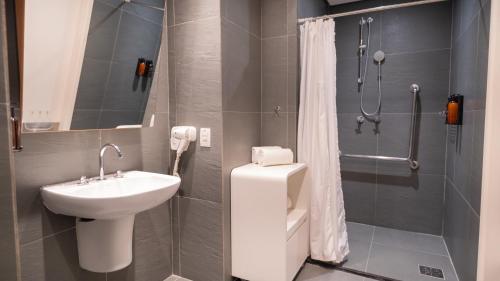 a bathroom with a sink and a toilet and a shower at Golden Tower Maracanaú by Fênix Hotéis in Maracanaú