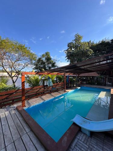 a large blue swimming pool with a wooden deck at Pousada Recanto das Chalanas in Corumbá