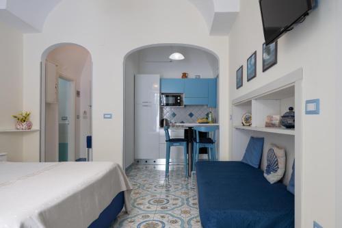 a bedroom with a bed and a kitchen with a table at Libeccio - flat with terrace and sea view, perfect for up to 3 guests in Maiori
