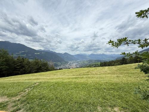 a field of green grass with mountains in the background at Fuchsmaurer Plose - Apartments bei Brixen in Bressanone