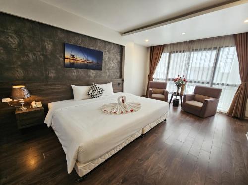 a bedroom with a large white bed and a chair at Moon Luxury Hotel in Hanoi