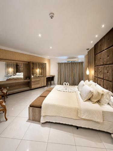 a large bedroom with a large bed and a desk at Granterrara Hotel in Jequié