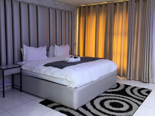 a bedroom with a bed with a cat toy on it at Giyani Shamba Lodge in Giyani