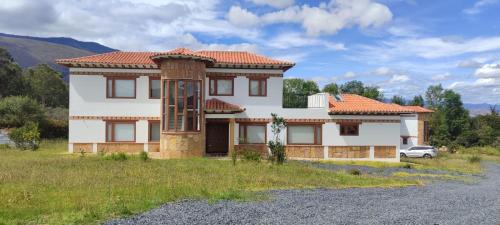 a white house with an orange roof at Casas Villa de Leyva in Villa de Leyva