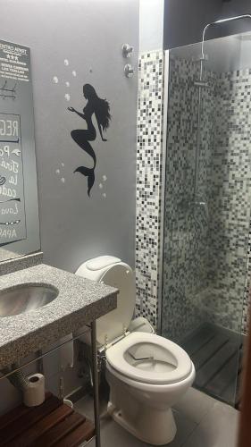 a bathroom with a mermaid stencil on the wall at Centro Apart in Villa Elisa