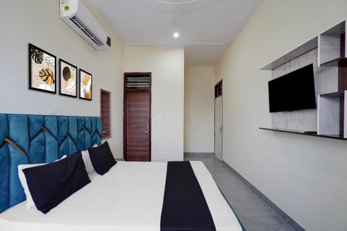 a bedroom with a bed and a tv on a wall at Hotel O The Signature Residency in Rohtak