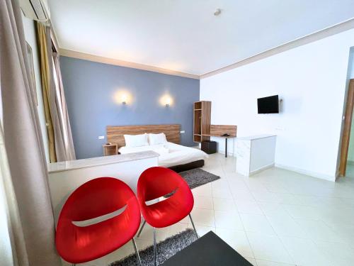 a bedroom with two red chairs and a bed at Hôtel Olympic in Fez
