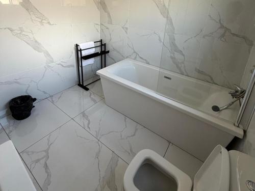 a white bathroom with a toilet and a urinal at Giyani Shamba Lodge in Giyani