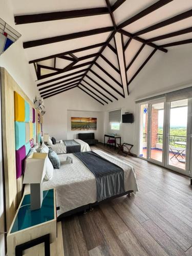 a bedroom with a large bed and a large window at CASA BOHEMIA - Resort de Cerveza y vino in Campoalegre