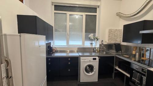 a kitchen with a refrigerator and a washing machine at La bulle dunkerquoise in Coudekerque-Branche