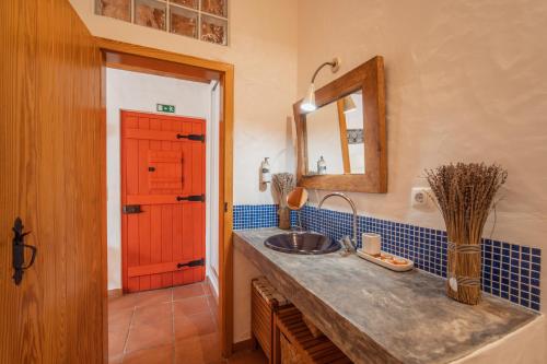 a bathroom with a sink and a red door at Cerca do Sul in Brejao