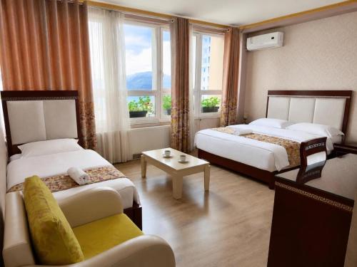 a hotel room with two beds and a window at British Hotel Pogradec in Pogradec