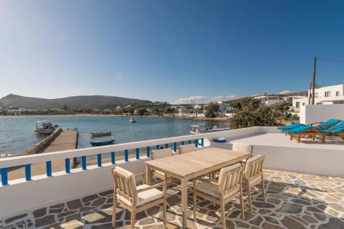 a table and chairs on a balcony overlooking the water at Pera Milos villa in Pollonia