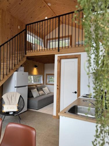 a kitchen and a living room with a staircase at Lake Hideaway with BBQ, Fire Pit & Horses in Sainte-Marguerite
