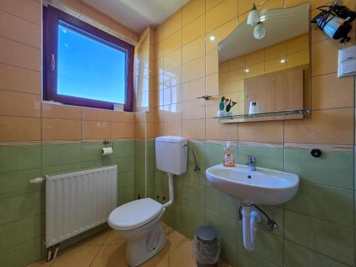 a bathroom with a toilet and a sink and a window at Guest House Bunčić Rooms & Apartments in Slunj