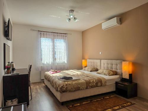 a bedroom with a large bed and a window at Guest House Bunčić Rooms & Apartments in Slunj