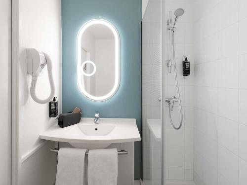 a bathroom with a sink and a mirror and a shower at ibis Nancy-Brabois in Vandoeuvre-lès-Nancy