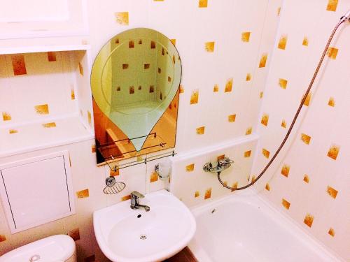 a bathroom with a sink and a toilet and a mirror at Apartment on Infinity Astana in Astana
