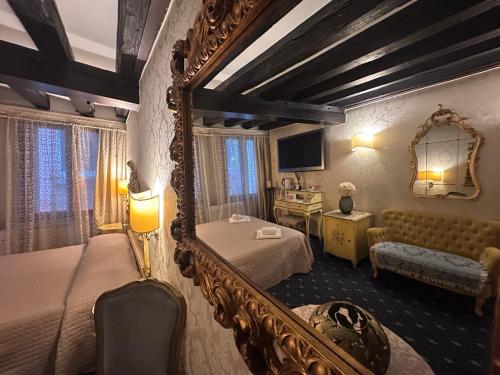 a bedroom with a mirror and a bed and a couch at Ca' Della Loggia in Venice
