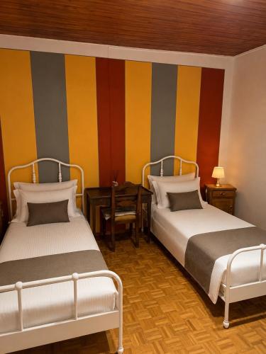 two beds in a room with colorful striped walls at Casa Fulvia by Lago Maggiore Rentals & Estate in Cannobio