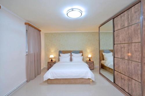 a bedroom with a large white bed and a mirror at Kaskade House in Yerevan