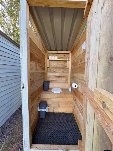 a wooden sauna with a toilet in it at Hedgerow hideaway in Llanvetherine