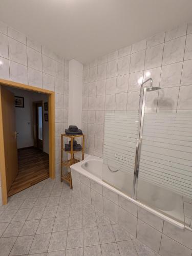 a bathroom with a tub and a walk in shower at Marktblick in Radeburg