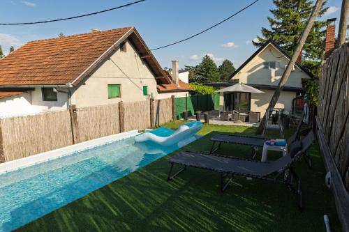 a backyard with a swimming pool and a house at Vikendica Mir Čortanovci in Čortanovci