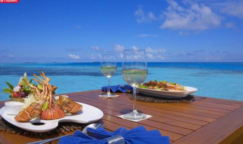 a table with wine glasses and a plate of food on the beach at MIRABELLA SOL CARIBE SUITES playa LOS CORALES in Punta Cana