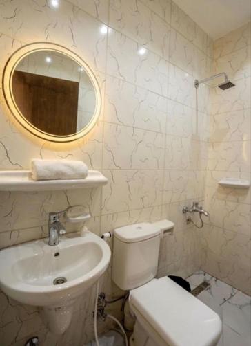 a bathroom with a sink and a toilet and a mirror at Explore Pyramids View in Cairo