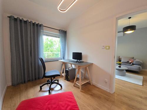 a room with a desk with a computer and a chair at Apartamenty Wichrowa in Żywiec