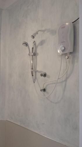 a shower head on a wall in a bathroom at Yaye Guest House in Tissamaharama