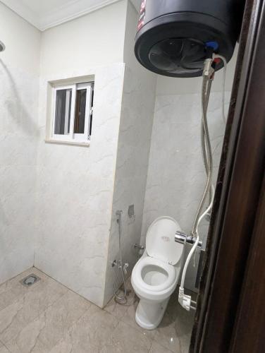 a bathroom with a toilet and a window at Shazi Heights in Lahore