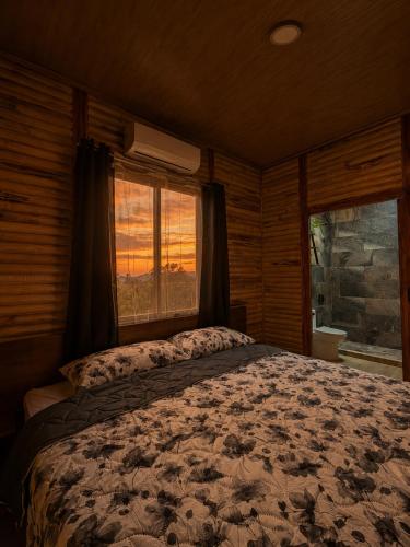 a bedroom with a bed and a large window at Cabaña Lancero in San Pedro