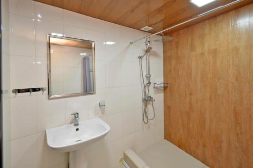 a white bathroom with a sink and a mirror at Kaskade House in Yerevan