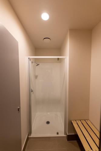 a shower stall in a bathroom with a bench at Otago Village in Dunedin