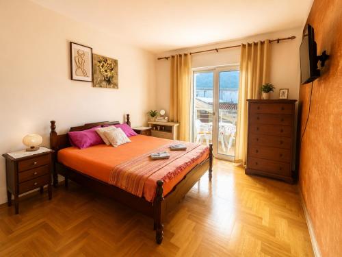 a bedroom with a bed with orange sheets and pink pillows at SeaSideApartman3 in Budva