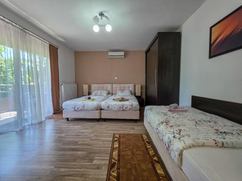 a bedroom with two beds and a large window at Guest House Bunčić Rooms in Slunj